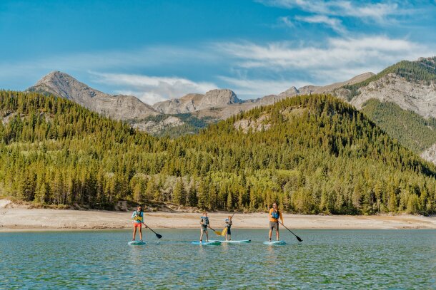 Family paddle boarding on Barrier Lake in Kananaskis Country