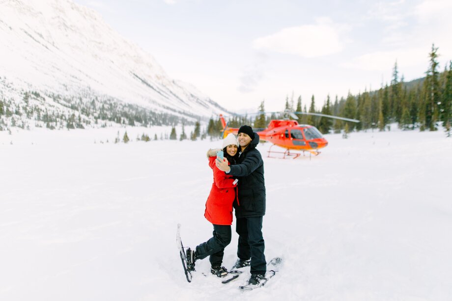 Couple taking a selfie in front of helicopter