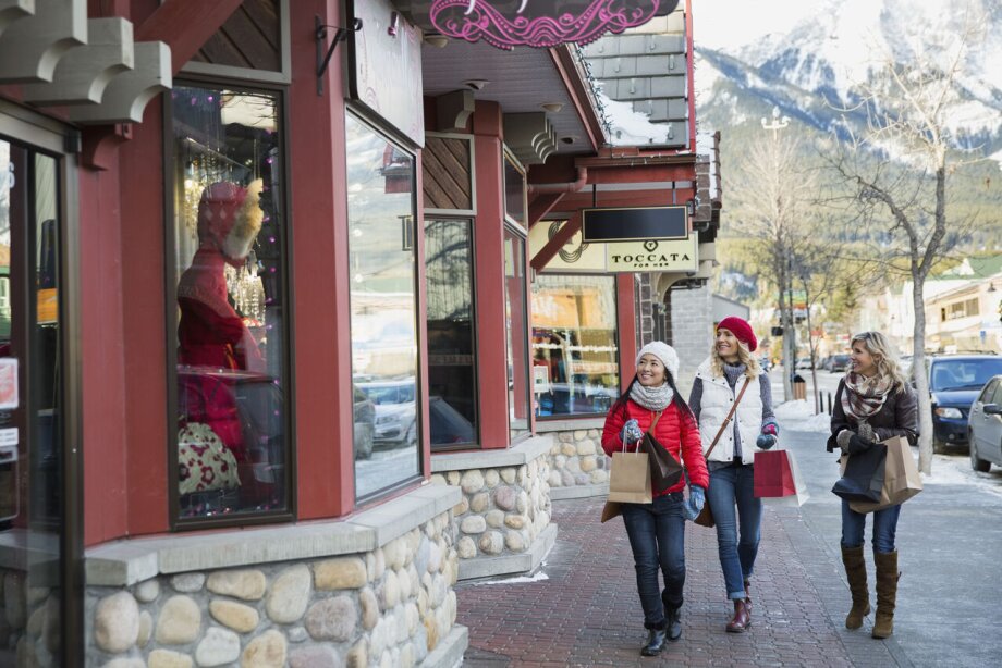 Women shopping and walking along a sidewalk in downtown Canmore
