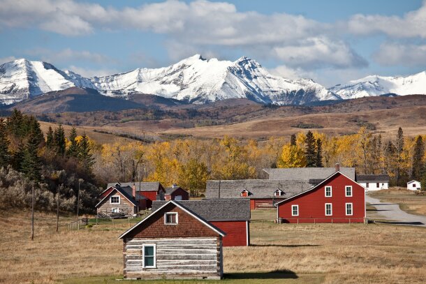 An exterior shot of Bar U Ranch National Historic Site with snow-capped mountains in the background in Longview