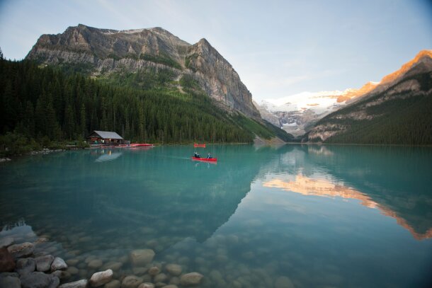 Scenic wide shot of the boat house and people canoeing on Lake Louise