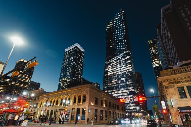 A street-level view of downtown Calgary at night along Stephen Avenue.