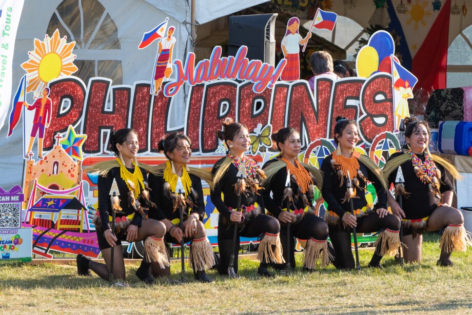Performers posing in front of Philippines sign at GlobalFest