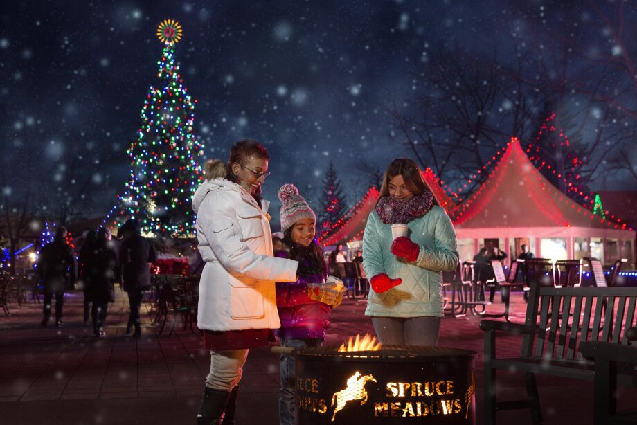 Family hanging around bonfire and christmas tree at spruce meadows christmas market
