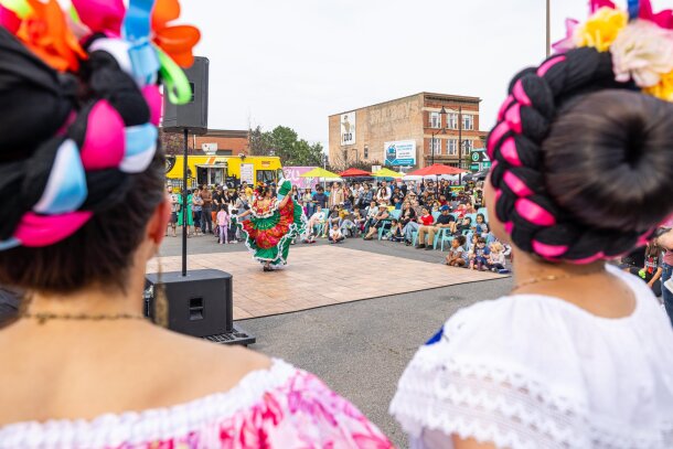 A dancer performs during Inglewood Sunfest framed by the heads of two other dancers.