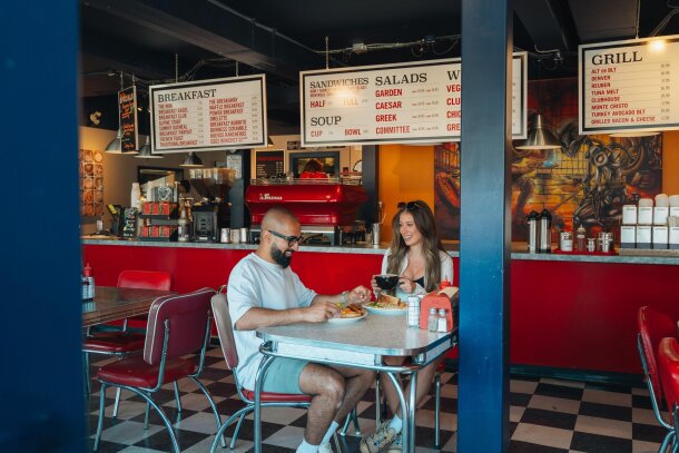 A man and a woman sitting down to breakfast at Cadence Coffee.