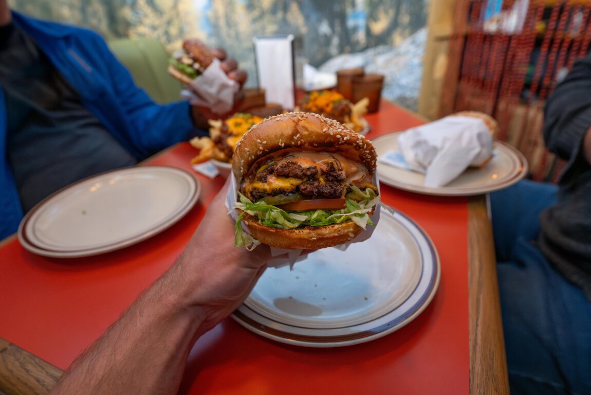 A person holding a burger at Class Clown.