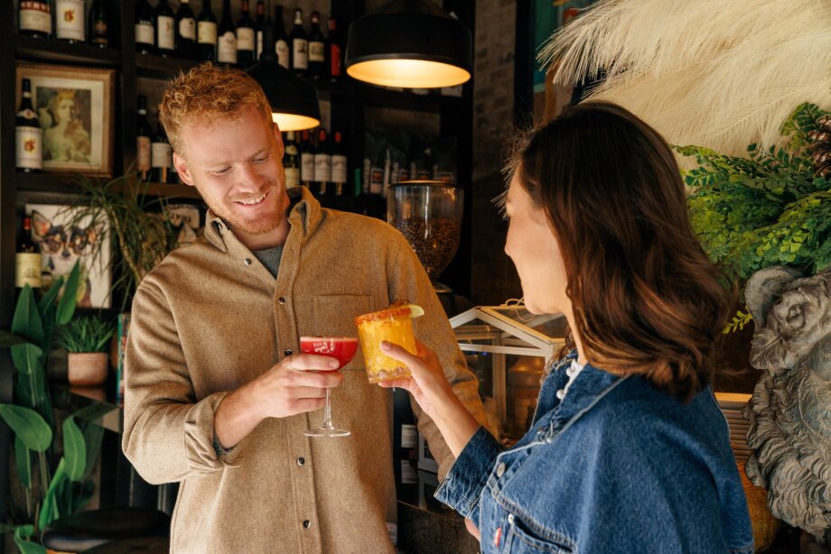 A man and a woman having breakfast cocktails at Queens.