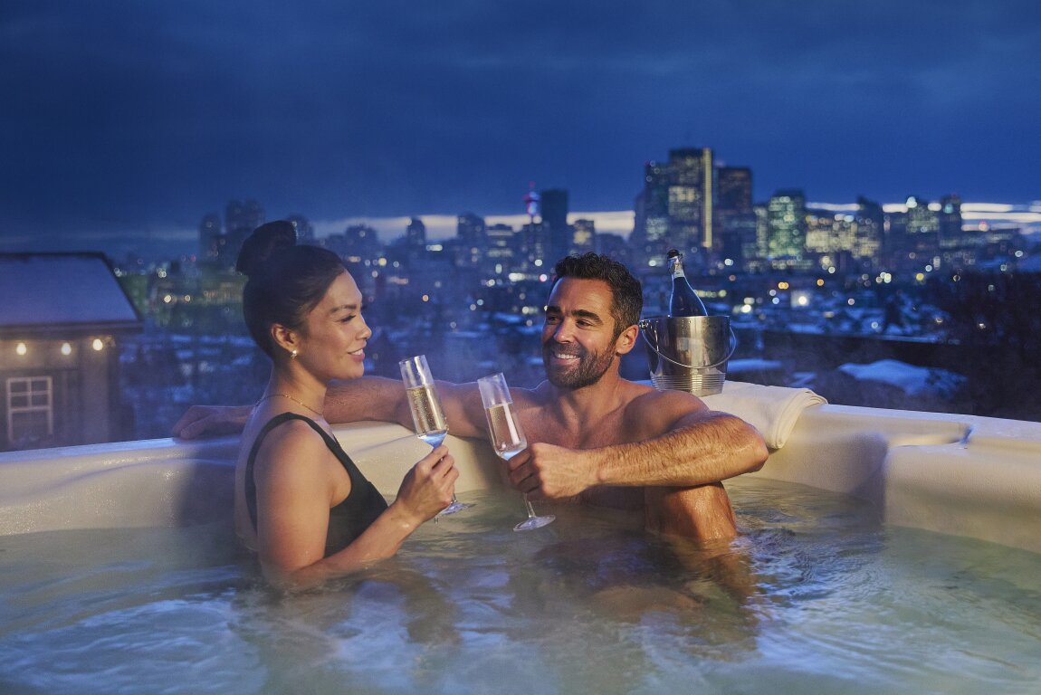 Couple relaxes at hot tub overlooking Calgary downtown skyline