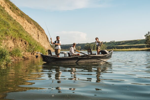 People fishing off a boat in the Bow River