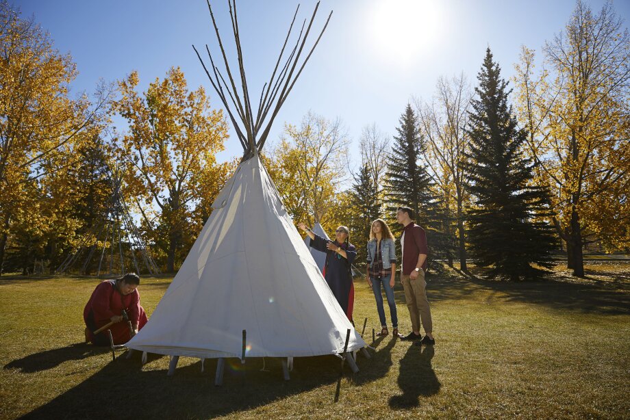 People learning how to set up a tipi at Heritage Park