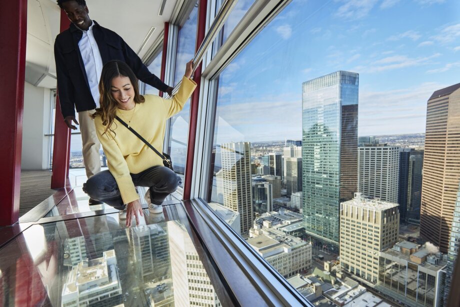 couple standing on the glass floor of the Calgary Tower observation deck