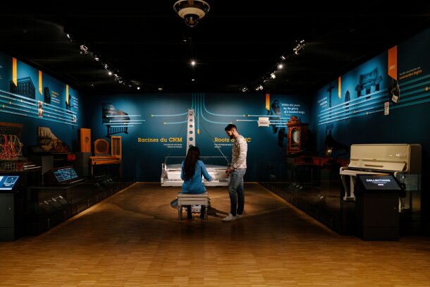 couple interacting with musical instrument exhibits at Studio Bell