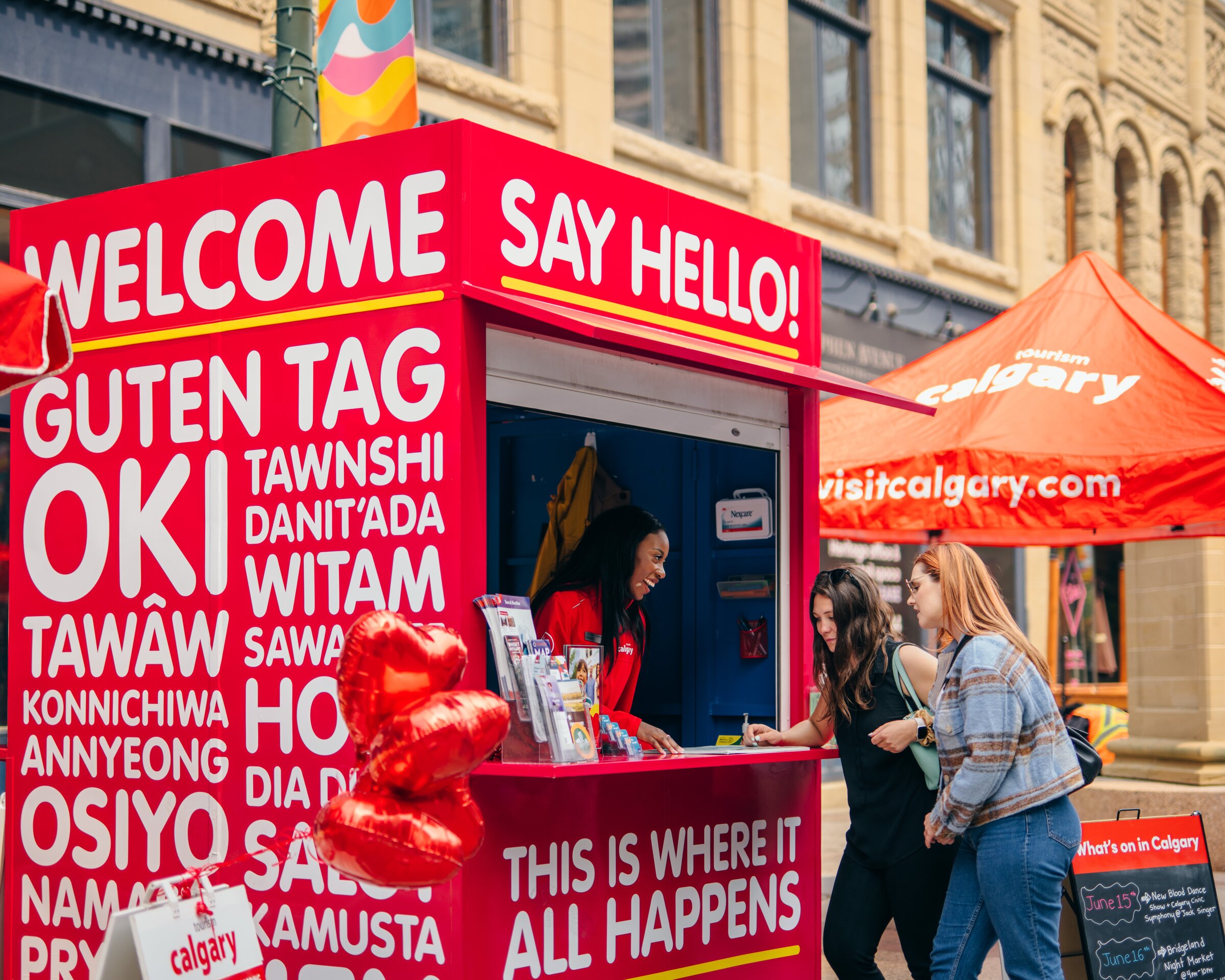 A travel counsellor on Stephen Avenue helps two visitors plan their trip.