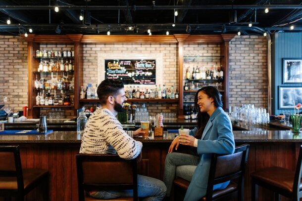 Couple having a drink at the King Eddy after exploring Studio Bell National Music Centre in Calgary