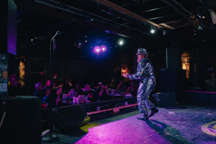Person performing on stage at Dickens bar