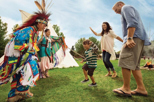 family dancing with Indigenous community at Heritage Park