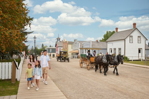 A family walking through the historical village at Heritage Park.