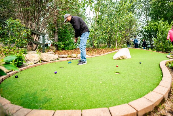 Two people playing mini golf