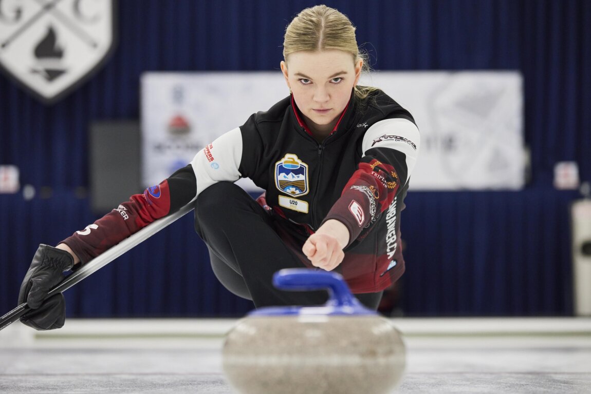 Female curler throwing rock