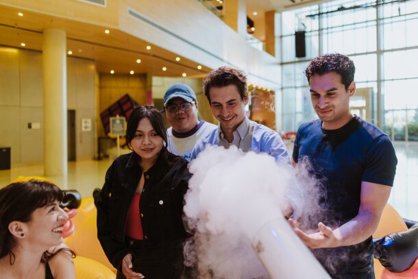Group of friends exploring smoke machine at TELUS Spark